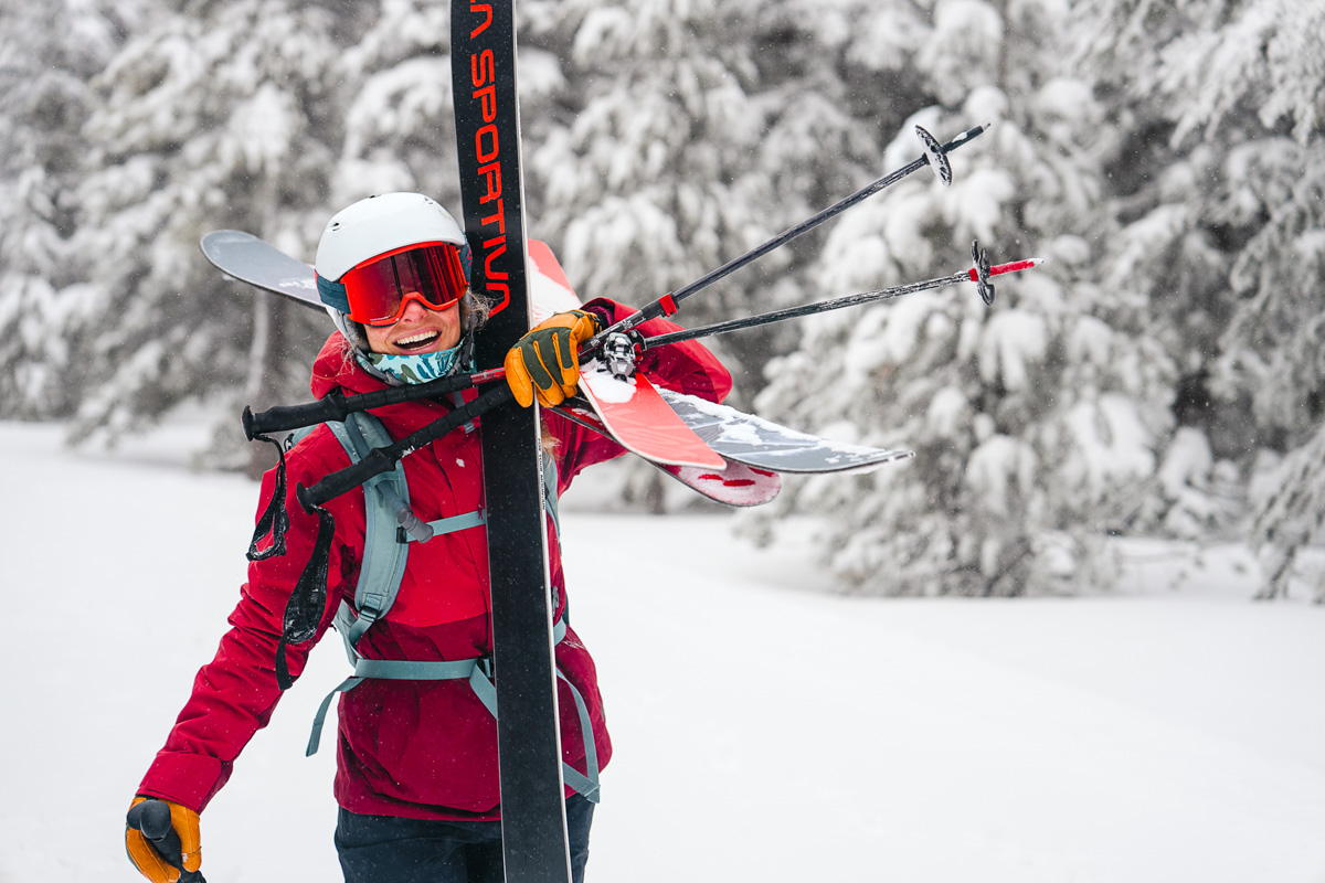 REI Co-op Powderbound (holding skis in snowy forest)